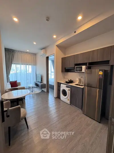 Modern open-plan living room with kitchen featuring sleek appliances and stylish decor