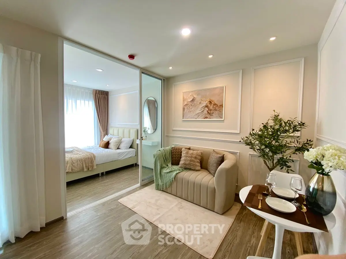 Elegant living room with cozy sofa and stylish decor adjacent to a modern bedroom.