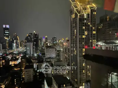 Stunning city skyline view from high-rise building at night, showcasing vibrant urban lights.