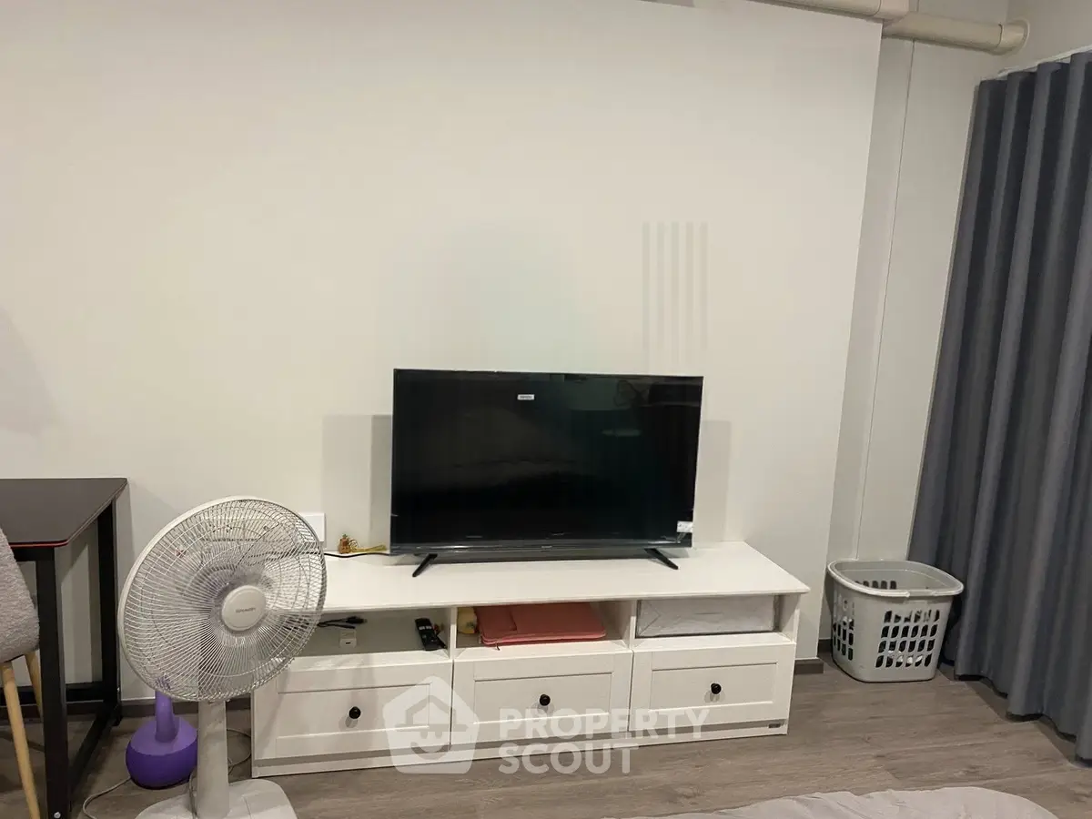 Cozy living room with modern TV setup and stylish furniture, perfect for relaxation and entertainment.