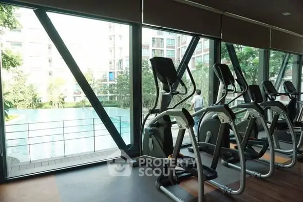 Modern gym with pool view in luxury residential complex