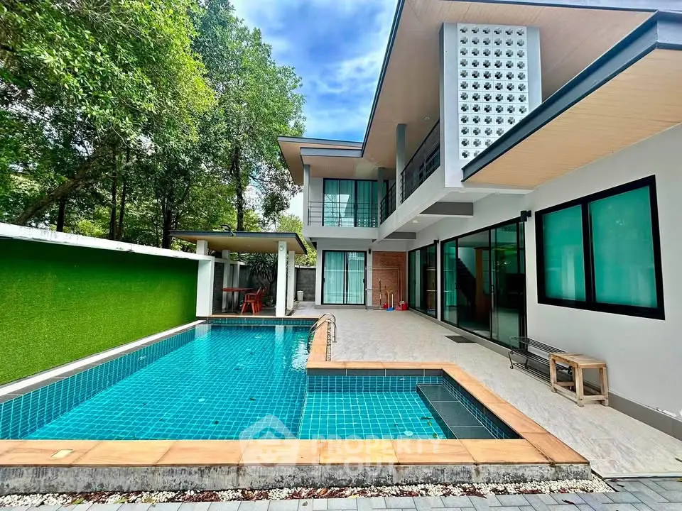 Modern luxury home with private pool and lush greenery, perfect for relaxation and entertaining.