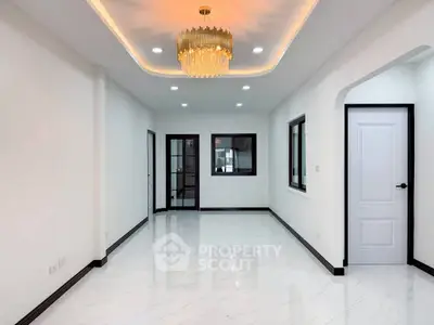 Elegant living room with modern chandelier and glossy white flooring