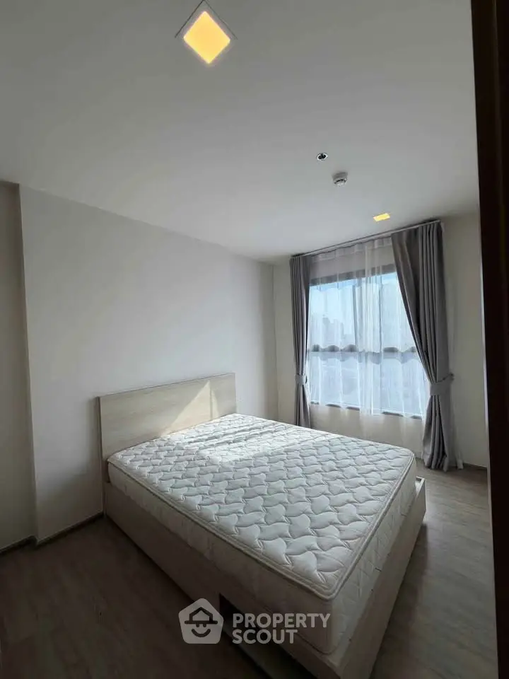 Spacious bedroom with natural light and modern decor in a stylish apartment.