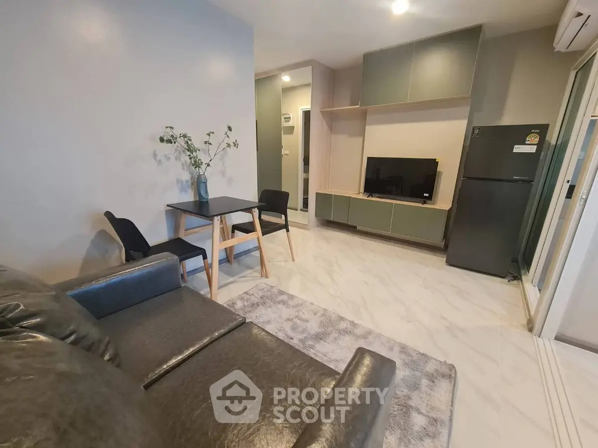 Modern living room with sleek furniture and open layout, featuring a cozy seating area and stylish decor.