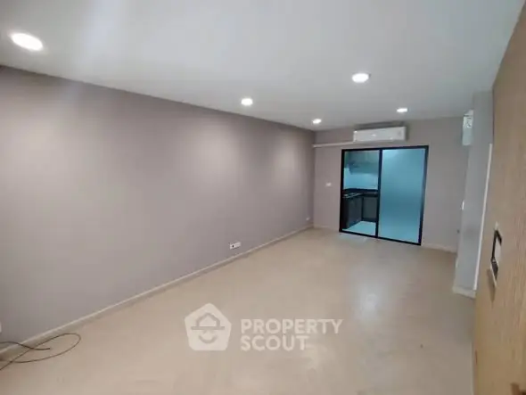 Spacious modern living room with sleek design and open kitchen view.