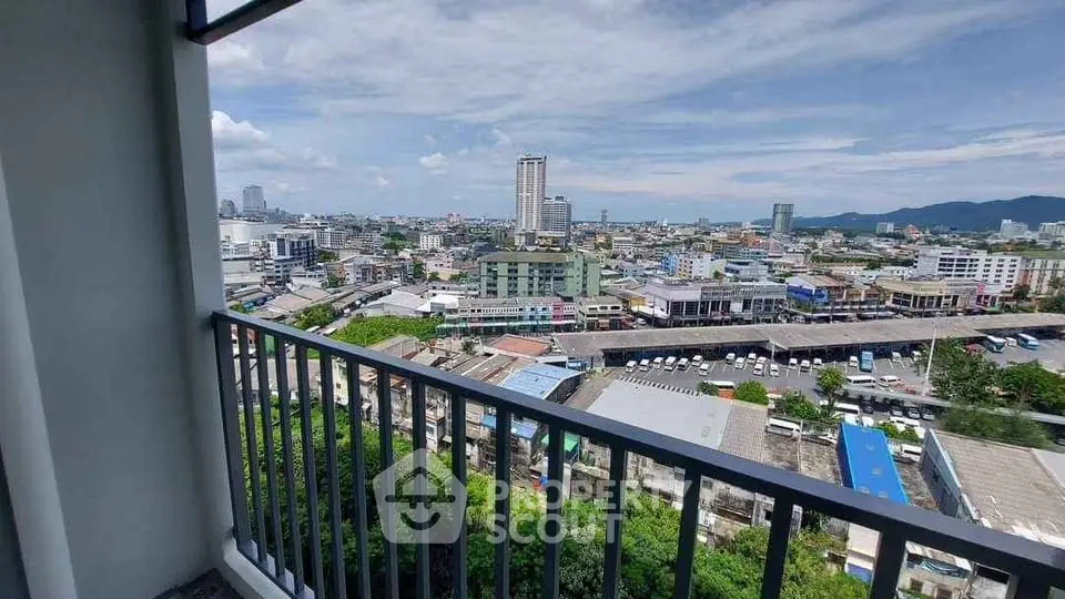 Stunning cityscape view from high-rise balcony with clear blue sky.