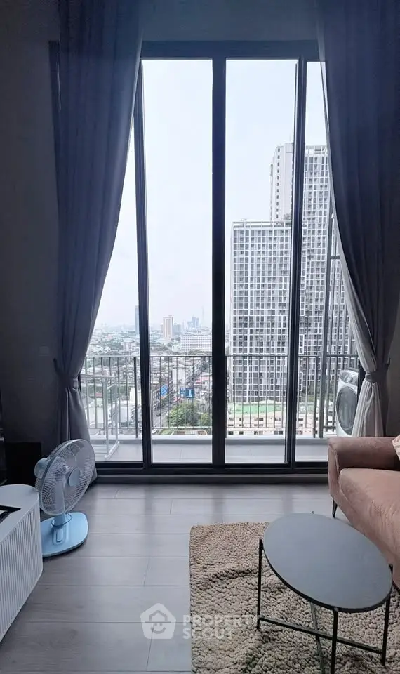 Modern living room with floor-to-ceiling windows offering stunning city views, cozy seating, and elegant decor.
