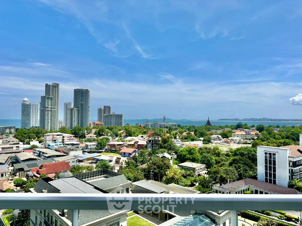 Stunning cityscape view from a high-rise balcony overlooking urban skyline and ocean horizon.