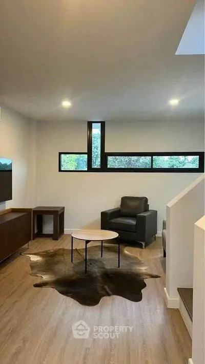 Modern living room with sleek furniture and large windows offering natural light.