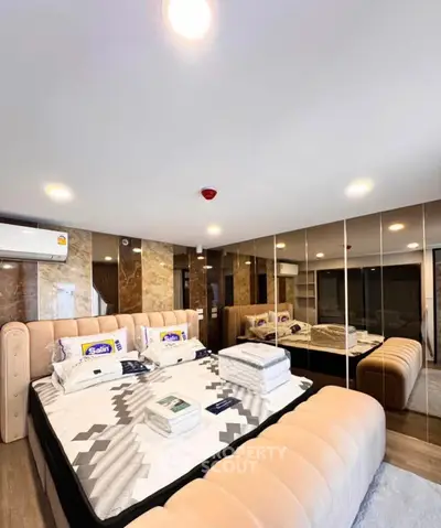 Luxurious bedroom with mirrored walls and plush bed in modern apartment