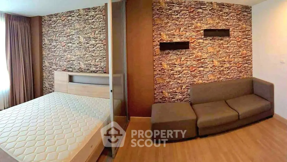Modern bedroom with stylish stone accent wall and cozy sofa