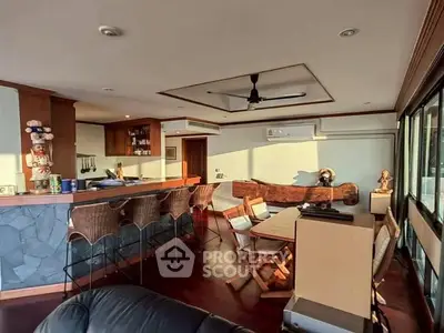 Spacious living room with bar and natural light, ideal for entertaining.