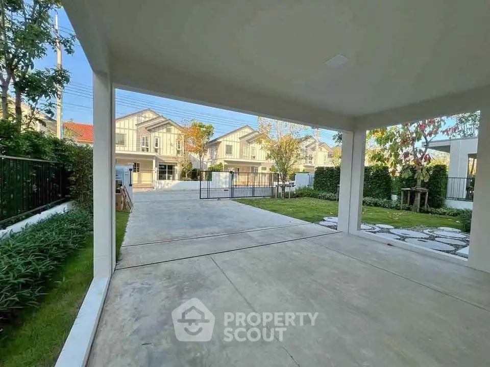 Spacious driveway with modern houses and lush greenery in a serene neighborhood.