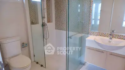 Modern bathroom with glass shower and mosaic tile accents