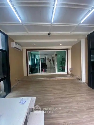 Spacious interior with modern flooring and large windows, perfect for versatile living space.