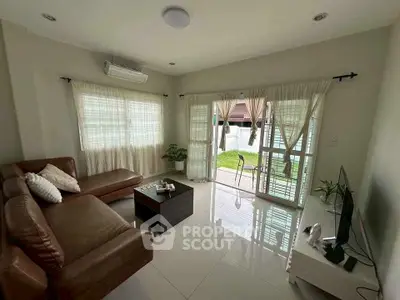 Cozy living room with leather sofa and garden view, perfect for relaxation.