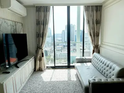 Modern living room with city view, elegant decor, and large TV setup.