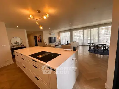 Spacious open-plan living room with modern kitchen island and elegant lighting.