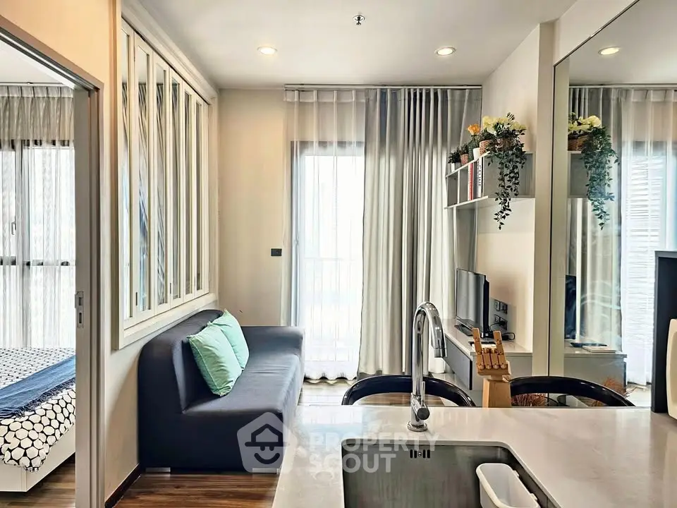 Modern open-layout living room with kitchen and stylish decor in a cozy apartment.