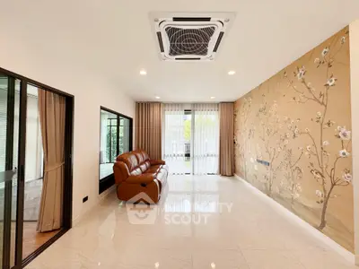 Spacious living room with elegant floral accent wall and modern air conditioning.
