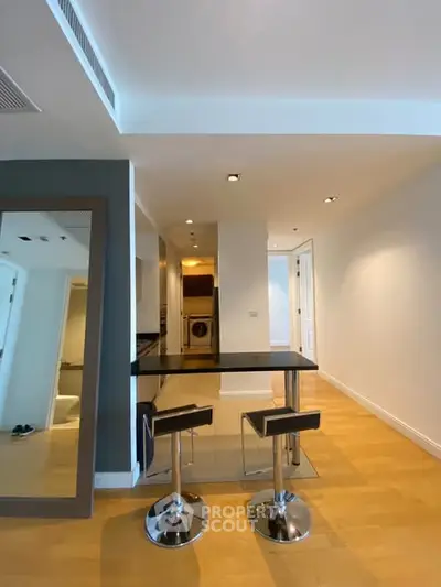 Modern kitchen with sleek bar stools and open layout in stylish apartment