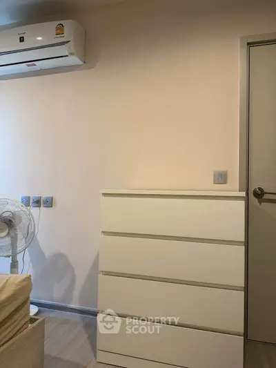 Modern bedroom with air conditioning and sleek white dresser