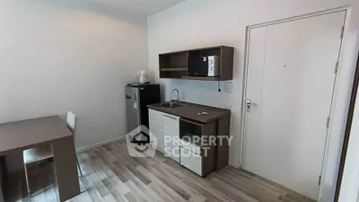 Modern compact kitchen with sleek cabinetry and integrated appliances in a stylish apartment.