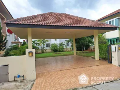 Spacious covered parking area with tiled flooring and garden view in suburban home