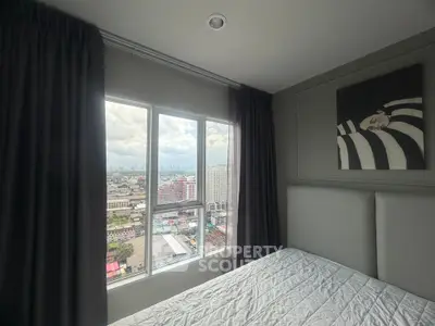 Modern bedroom with large window offering stunning city views, featuring elegant decor and cozy ambiance.