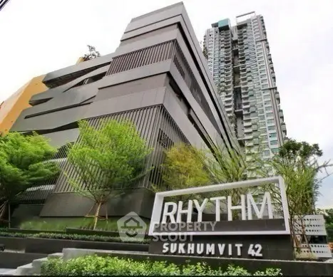 Modern high-rise building exterior with lush greenery at Rhythm Sukhumvit 42.