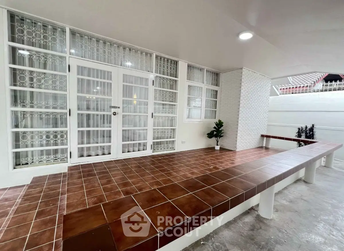 Spacious modern entrance with tiled flooring and glass-paneled doors, perfect for welcoming guests.