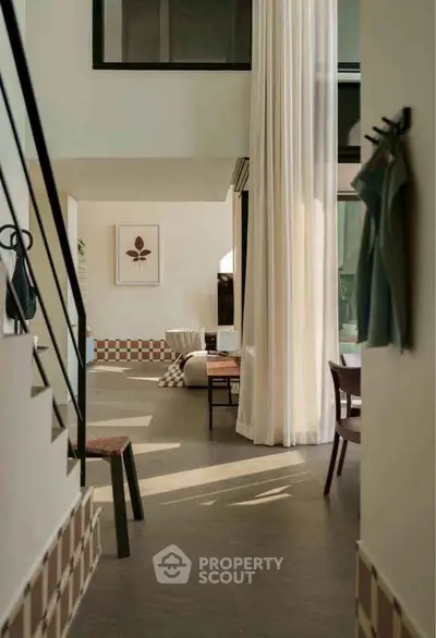 Modern living room with high ceilings and elegant decor, featuring natural light and stylish furniture.