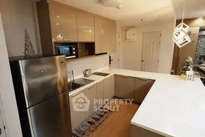 Modern kitchen with sleek cabinetry and stainless steel appliances in a stylish apartment.
