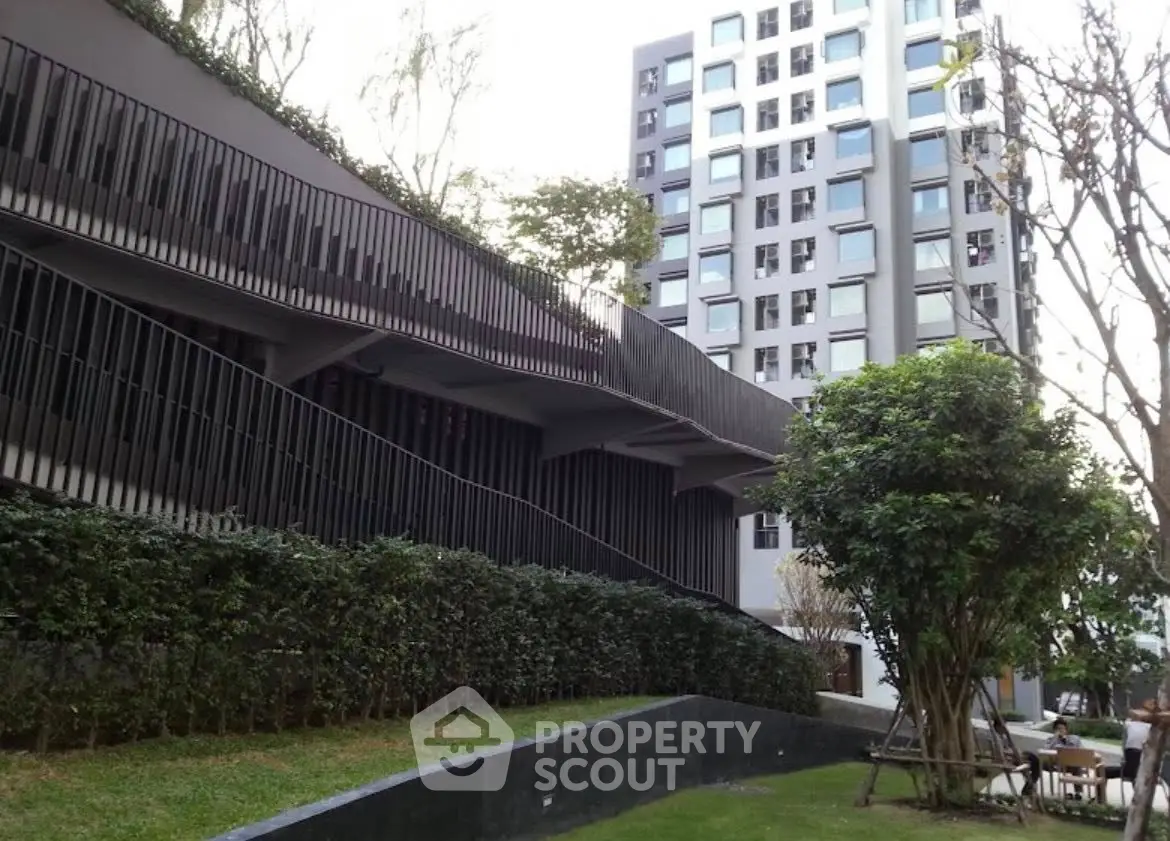 Modern apartment building with lush garden and unique architectural design.