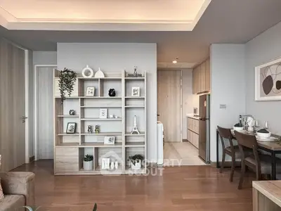 Modern living room with stylish shelving and dining area in open layout apartment.