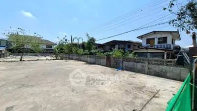 Spacious residential plot with potential for development, surrounded by houses and greenery.