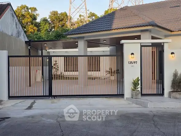Modern house exterior with gated entrance and sleek design.