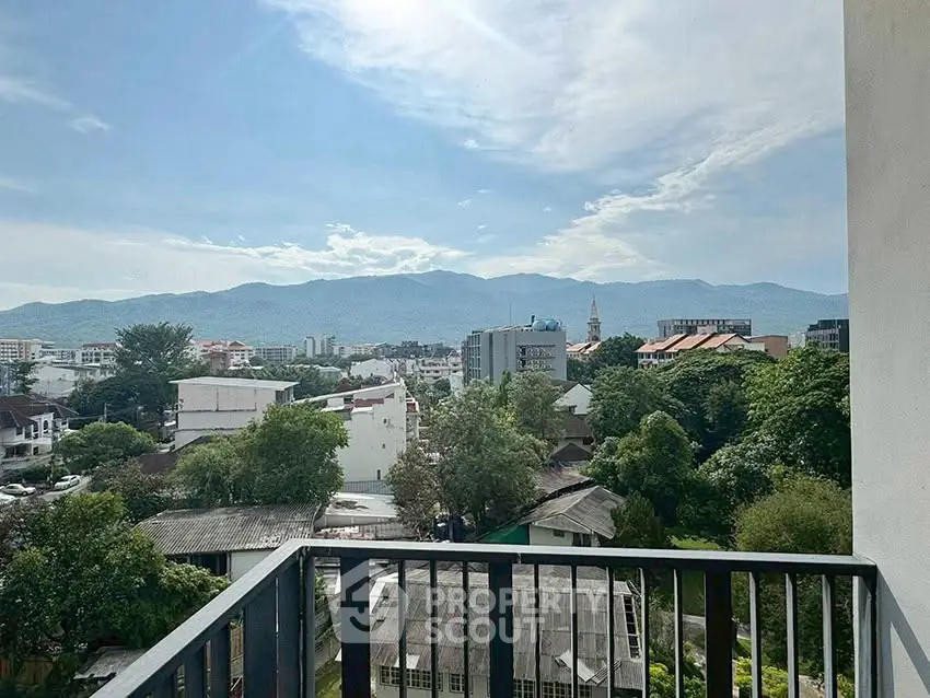 Stunning balcony view overlooking lush greenery and distant mountains, perfect for serene living.