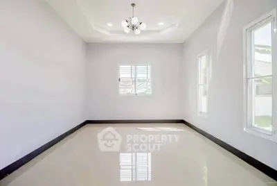 Spacious and bright empty room with glossy tiled floor and modern chandelier, perfect for customization.