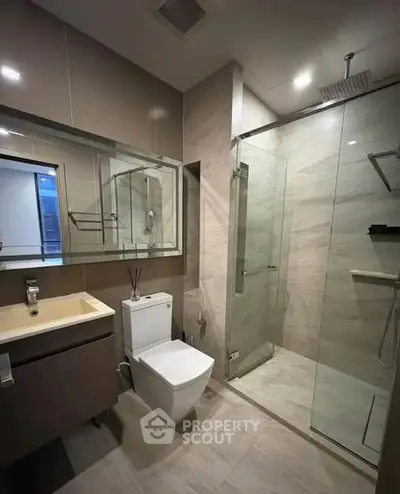 Modern bathroom with glass shower and sleek fixtures in a contemporary home.