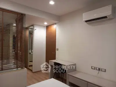 Modern bedroom with air conditioning and study desk, featuring sleek design and neutral tones.