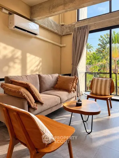Stylish living room with modern furniture and large windows offering lush garden views.