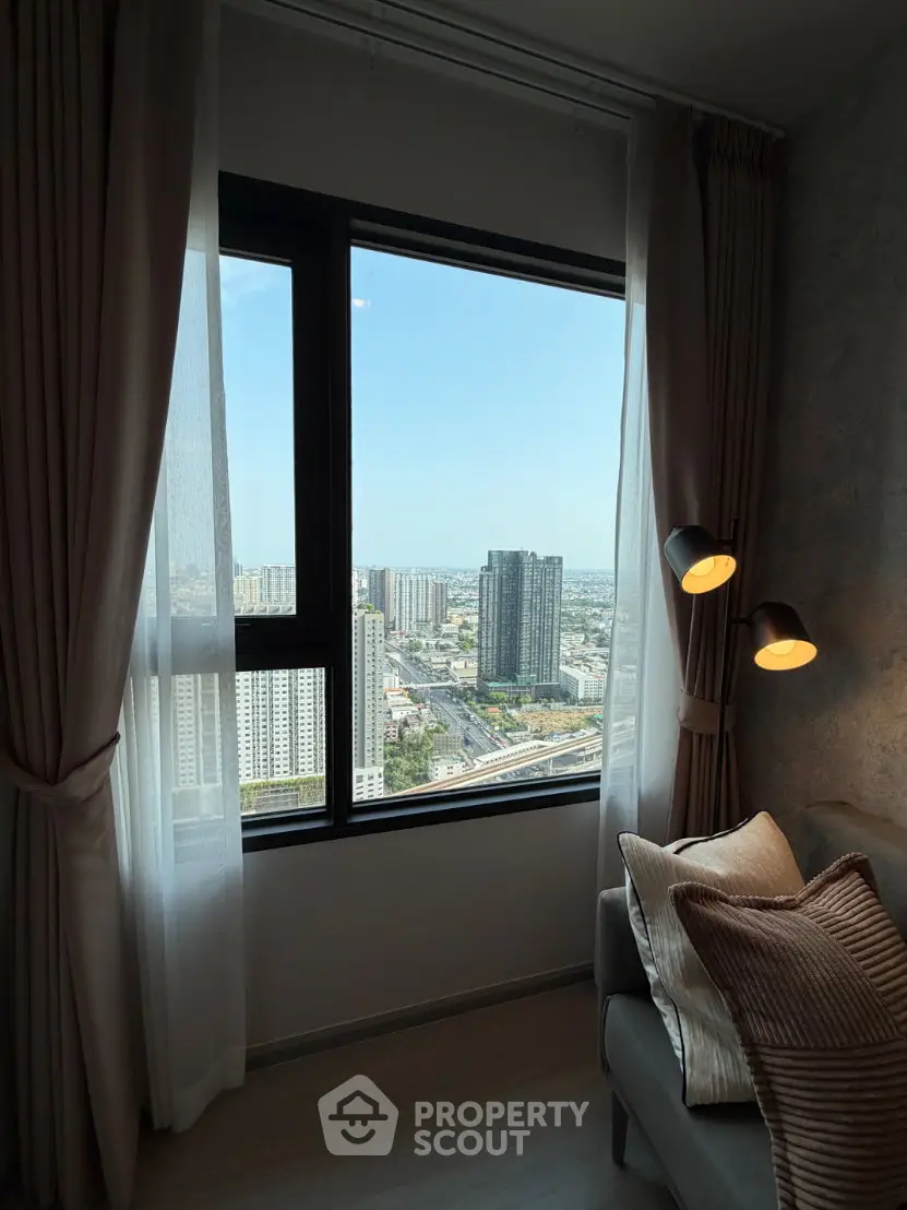 Stunning city view from a cozy living room with elegant decor and large window.