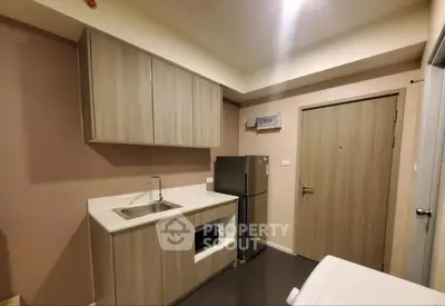 Modern kitchen with sleek cabinetry and stainless steel appliances in compact layout.