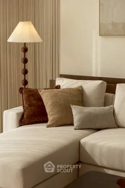 Elegant living room with plush sofa and stylish lamp, perfect for cozy relaxation.
