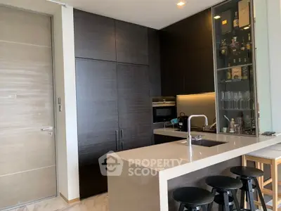 Modern kitchen with sleek dark cabinets and breakfast bar seating