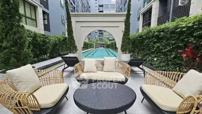 Luxurious outdoor pool area with stylish seating in modern apartment complex.