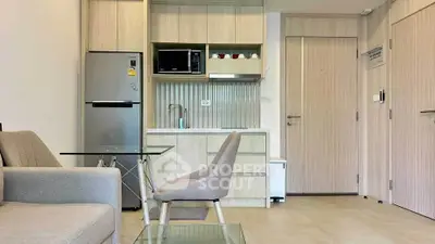 Modern kitchen with sleek appliances and cozy dining area in stylish apartment.