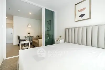 Modern bedroom with elegant decor and view into cozy dining area, perfect for urban living.